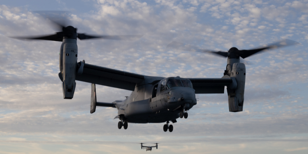 Two U.S. Marine Corps MV-22B Osprey tiltrotor aircraft in flight against a cloudy sky during operations.