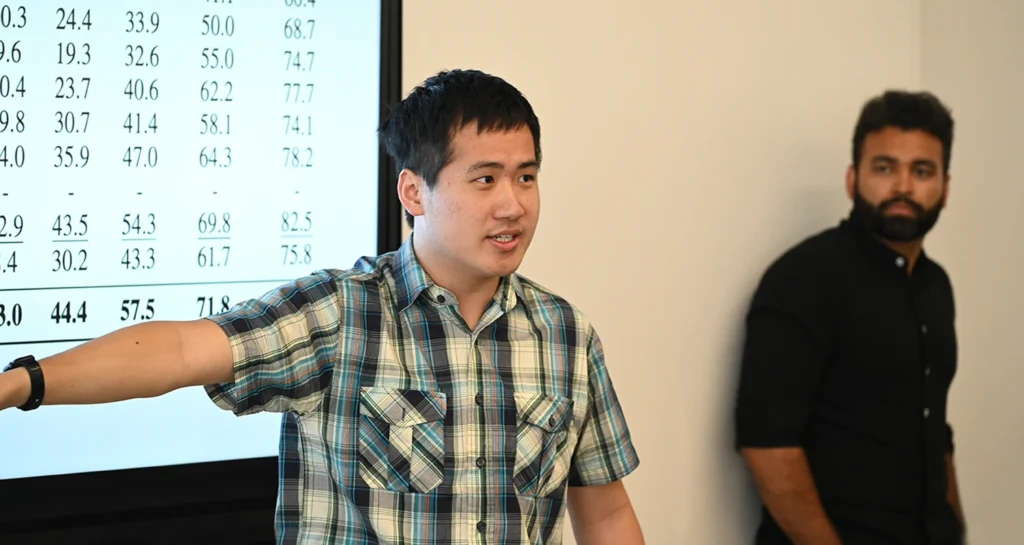Image of Virtualitics employee presenting data on a projected screen at meeting